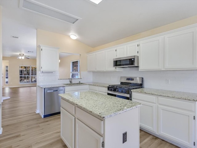 kitchen with white cabinetry, sink, vaulted ceiling, and appliances with stainless steel finishes