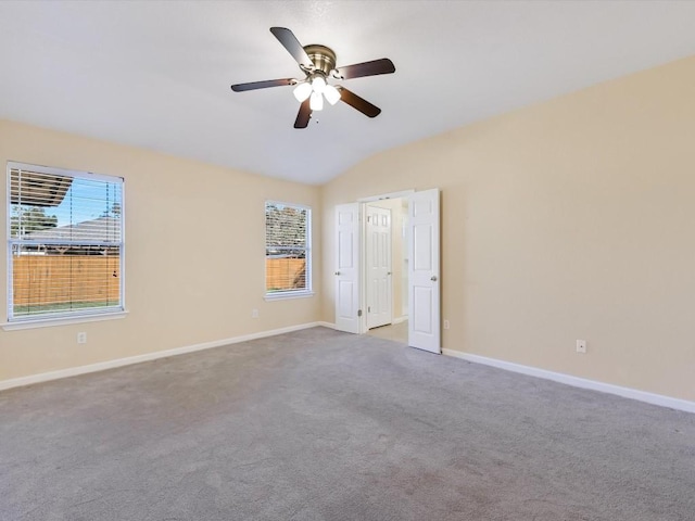 carpeted empty room featuring ceiling fan, a healthy amount of sunlight, and lofted ceiling