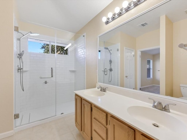 bathroom featuring toilet, tile patterned flooring, vanity, and walk in shower