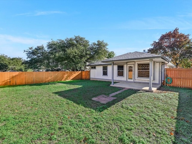 back of house with a patio area and a lawn