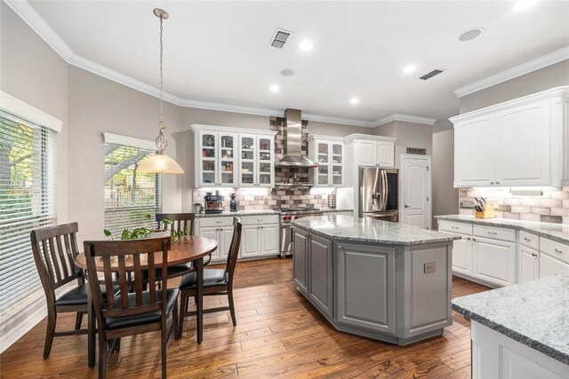 204 Woodland Park, Georgetown, TX 78633 - kitchen with gray cabinets, stainless steel appliances, white cabinets, range hood, and decorative backsplash