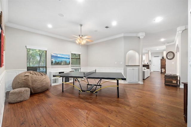 game room with ornate columns, hardwood / wood-style flooring, ceiling fan, and ornamental molding