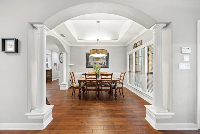 dining space with dark hardwood / wood-style floors, a raised ceiling, and crown molding