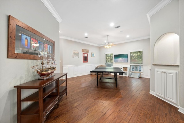 game room with crown molding, ceiling fan, and dark wood-type flooring