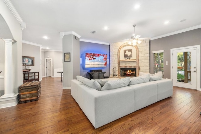 living room featuring hardwood / wood-style floors, a brick fireplace, ceiling fan, and crown molding