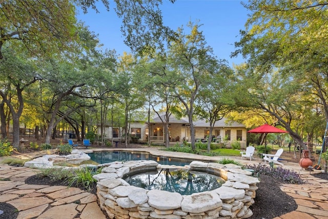 view of swimming pool featuring an in ground hot tub