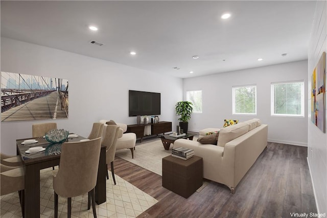 living room featuring baseboards, visible vents, wood finished floors, and recessed lighting