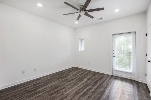 empty room with a ceiling fan, recessed lighting, dark wood finished floors, and baseboards