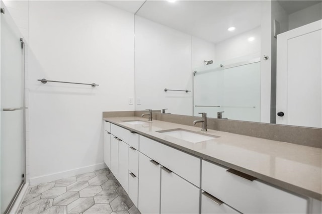 bathroom with double vanity, baseboards, a sink, and recessed lighting