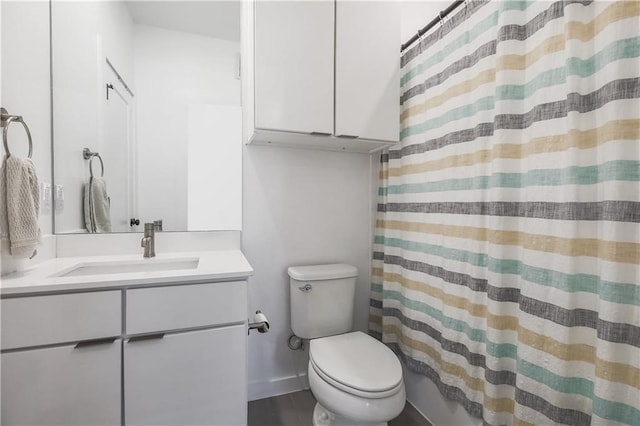 bathroom with toilet, baseboards, and vanity