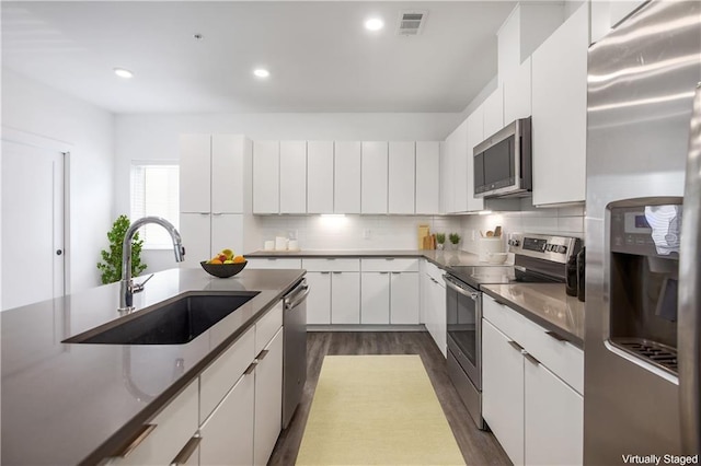 kitchen featuring white cabinetry, sink, dark hardwood / wood-style flooring, and stainless steel appliances