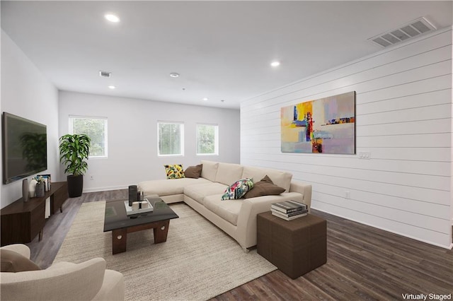 living room with hardwood / wood-style flooring and wooden walls