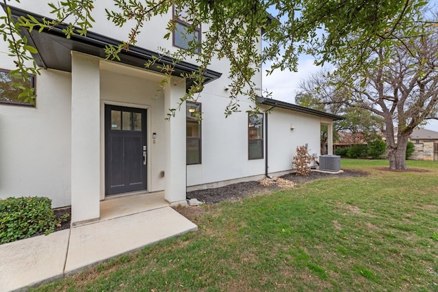 property entrance with a yard and central air condition unit