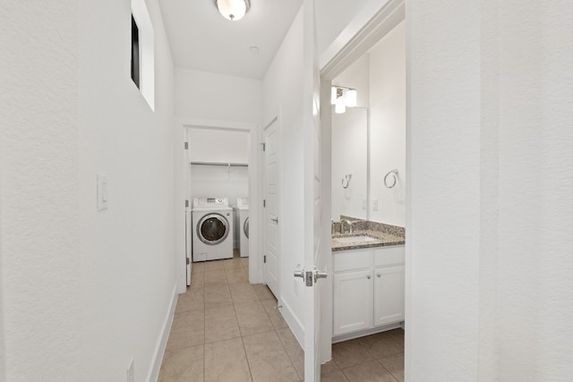 interior space with sink, light tile patterned floors, and washer and dryer