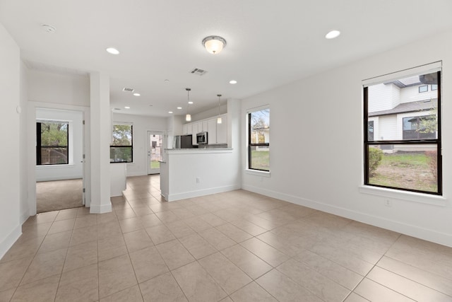 unfurnished living room with a wealth of natural light and light tile patterned flooring