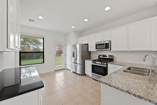 kitchen featuring light stone counters, white cabinetry, sink, and appliances with stainless steel finishes