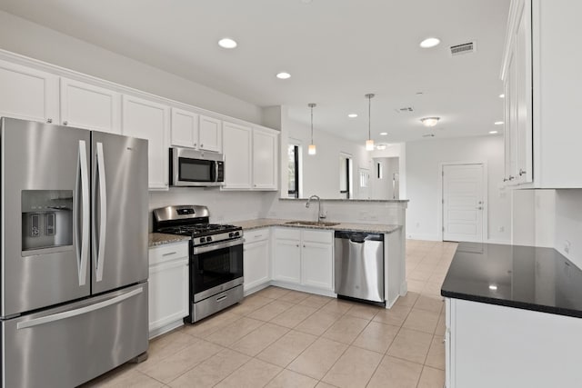 kitchen with white cabinetry, sink, decorative light fixtures, light tile patterned floors, and appliances with stainless steel finishes