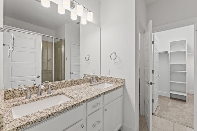 bathroom featuring tile patterned floors, vanity, and a shower with shower door