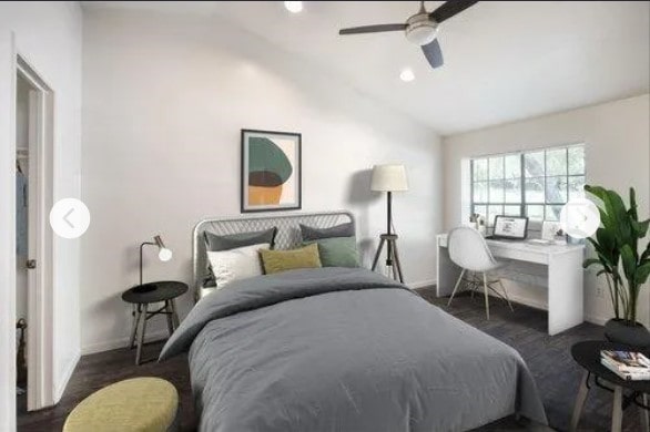 bedroom with dark hardwood / wood-style floors, vaulted ceiling, and ceiling fan