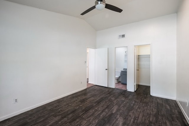 unfurnished bedroom with lofted ceiling, ensuite bathroom, ceiling fan, dark hardwood / wood-style flooring, and a closet