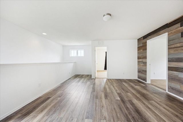 unfurnished room featuring hardwood / wood-style floors and wood walls