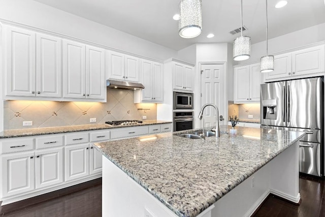 kitchen with decorative light fixtures, white cabinetry, an island with sink, and appliances with stainless steel finishes