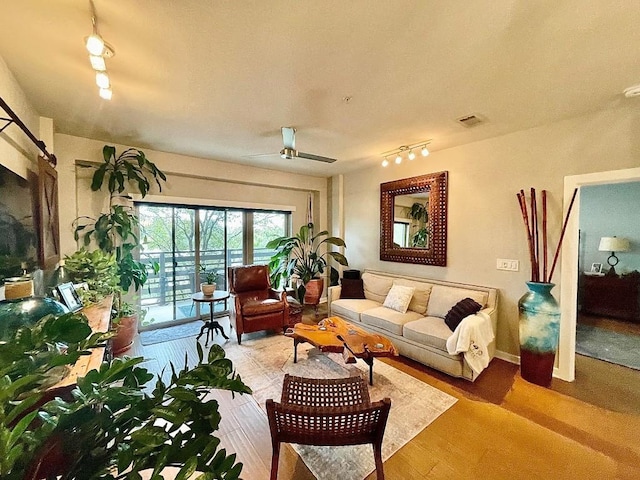 living room featuring hardwood / wood-style floors and ceiling fan