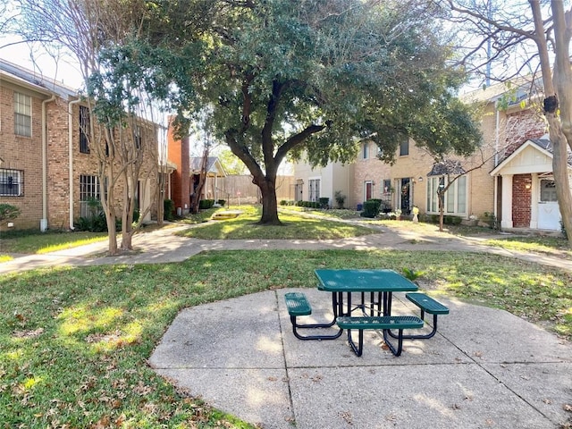 view of home's community with a patio and a lawn