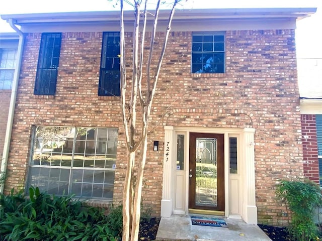 property entrance featuring brick siding