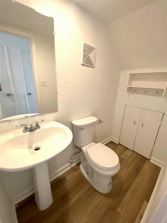 bathroom featuring toilet and wood-type flooring