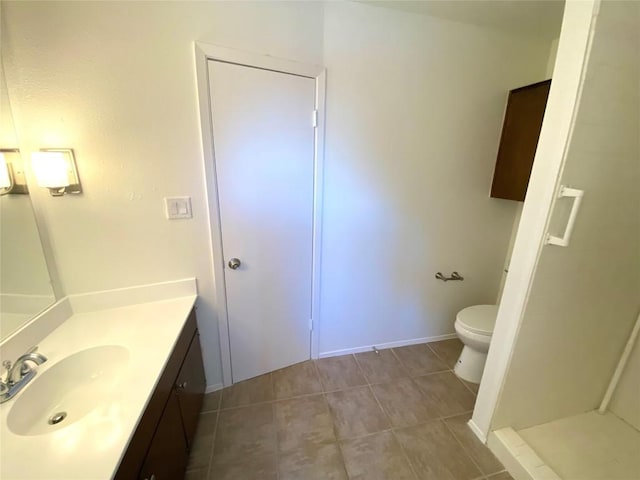 bathroom with tile patterned flooring, vanity, and toilet