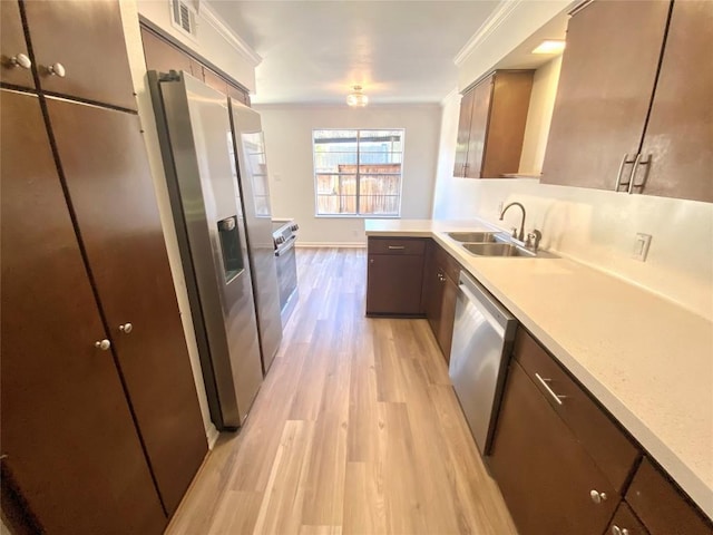 kitchen featuring dark brown cabinetry, sink, stainless steel appliances, light hardwood / wood-style flooring, and crown molding