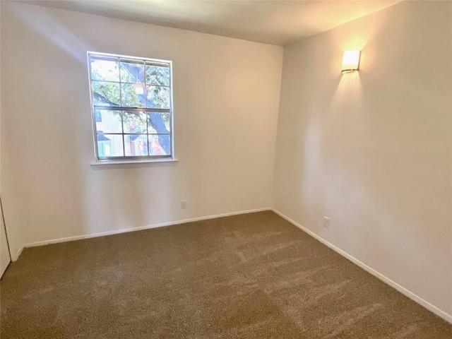 unfurnished room with dark carpet