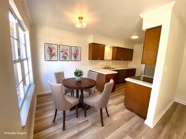 dining space with crown molding, sink, and light hardwood / wood-style floors