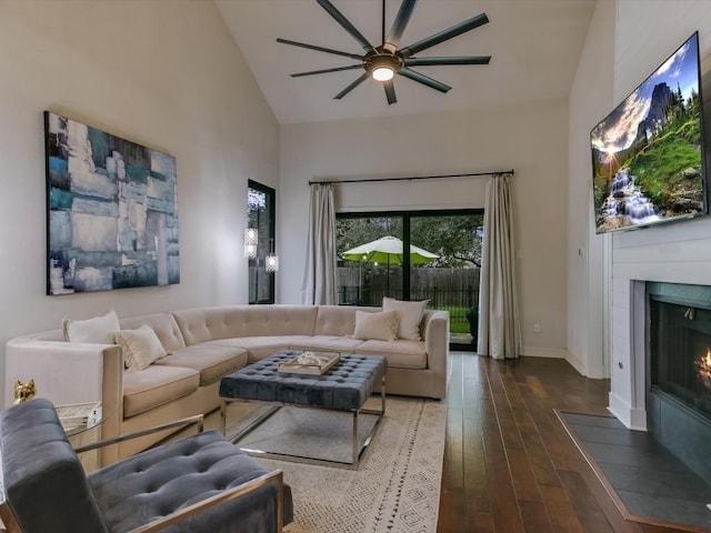 living room featuring ceiling fan, high vaulted ceiling, and dark wood-type flooring