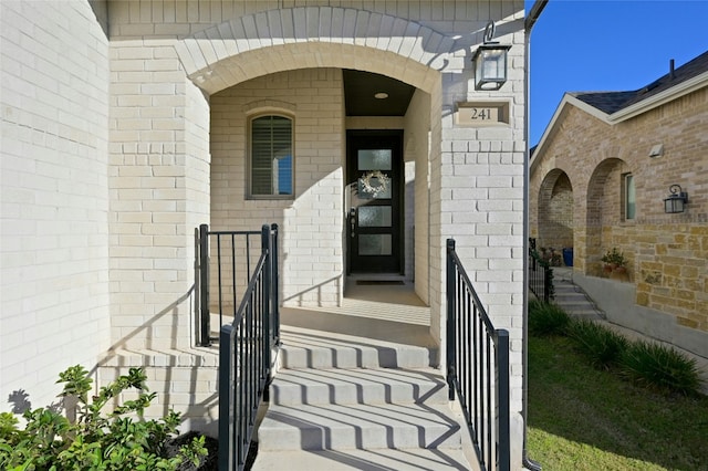 view of exterior entry featuring brick siding