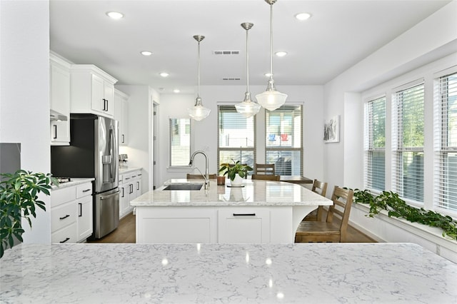 kitchen with a healthy amount of sunlight, visible vents, a sink, and white cabinetry