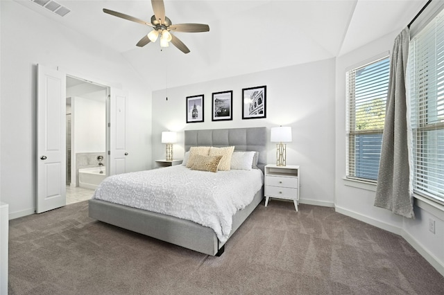 carpeted bedroom featuring a ceiling fan, visible vents, vaulted ceiling, baseboards, and ensuite bath