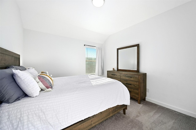 bedroom with lofted ceiling, carpet floors, and baseboards