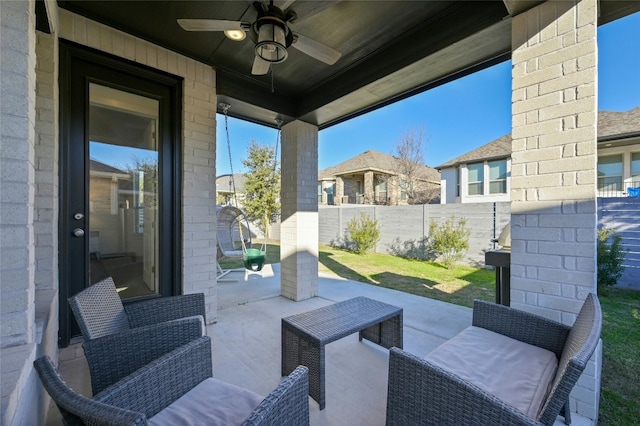 view of patio with outdoor lounge area, fence, and ceiling fan