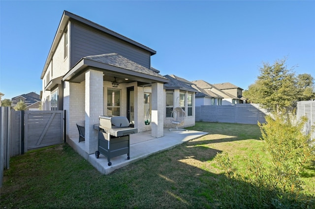 rear view of house featuring a patio area, a fenced backyard, a yard, and a gate