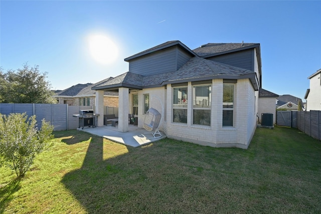 rear view of house with a patio area, a yard, a fenced backyard, and central AC unit