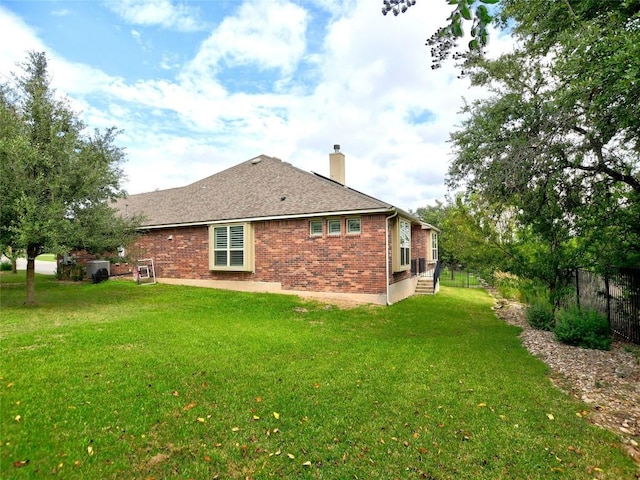 5021 Pyrenees Pass, Austin, TX 78738 - back of house featuring brick siding, a chimney, and a lawn