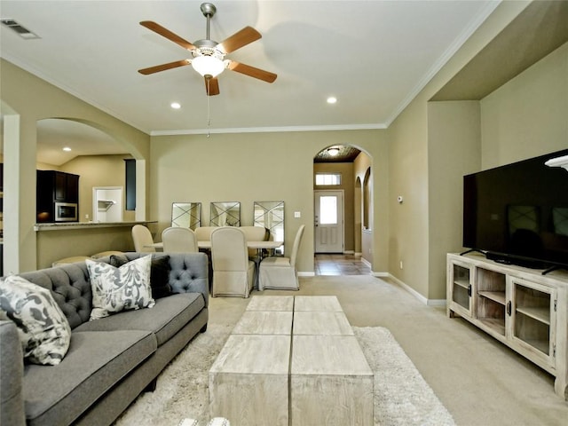 5021 Pyrenees Pass, Austin, TX 78738 - living area featuring arched walkways, light colored carpet, ornamental molding, ceiling fan, and baseboards