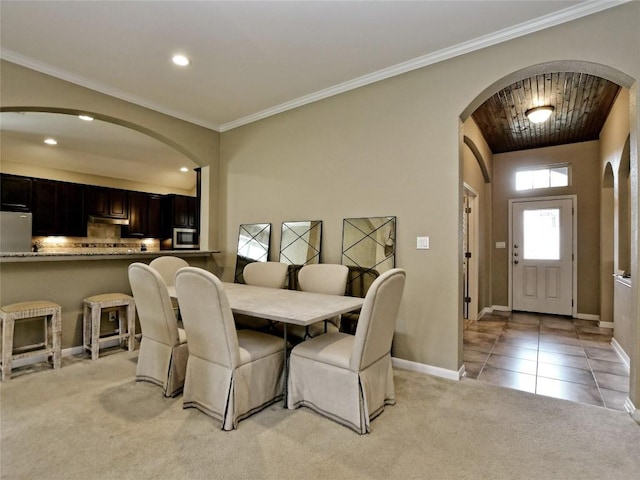 dining area with crown molding and light carpet