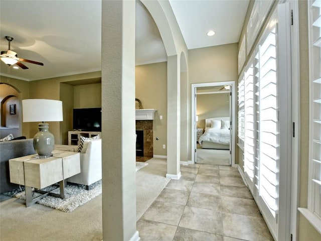 interior space with ceiling fan, light tile patterned floors, and a fireplace