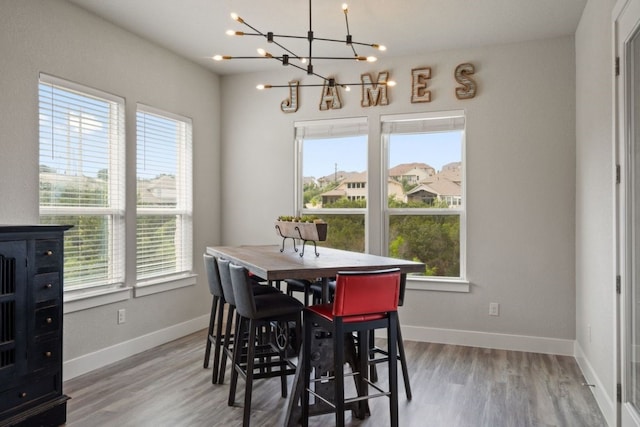 dining room featuring a wealth of natural light, a notable chandelier, and hardwood / wood-style flooring