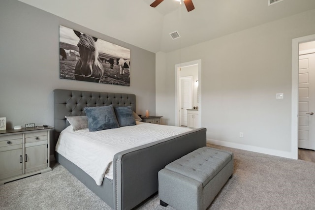 carpeted bedroom with ensuite bath, ceiling fan, and high vaulted ceiling