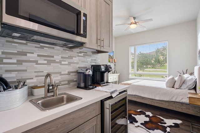 kitchen with decorative backsplash, sink, beverage cooler, and light brown cabinets