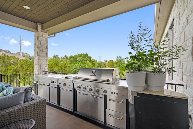 view of patio / terrace with outdoor lounge area, an outdoor kitchen, a grill, and sink